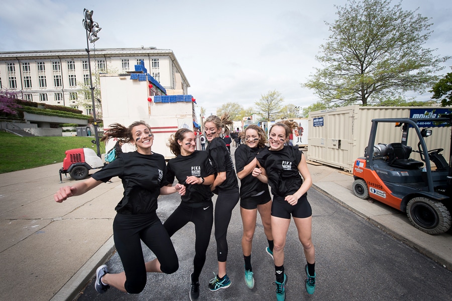 female buggy racing team at carnival smiles and jumps for a fun photograph